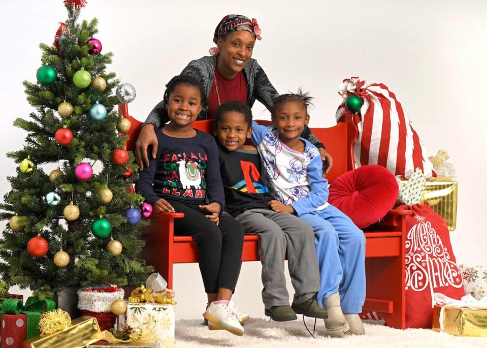 Lanease Draper of Kansas City with, from left, niece Zamyla Draper, 7, son Ledgyn Draper, 5, and daughter Lyryck Draper, 7, posed for a Christmas photo Saturday during the Soul of Santa holiday breakfast, toy and clothing giveaway. Star reporters, editors and photographers volunteered making portraits of the 22 families who attended.
