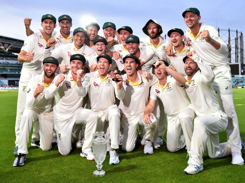 Australia's captain Tim Paine holds the Ashes Urn as the players celebrate victory: AFP/Getty Images