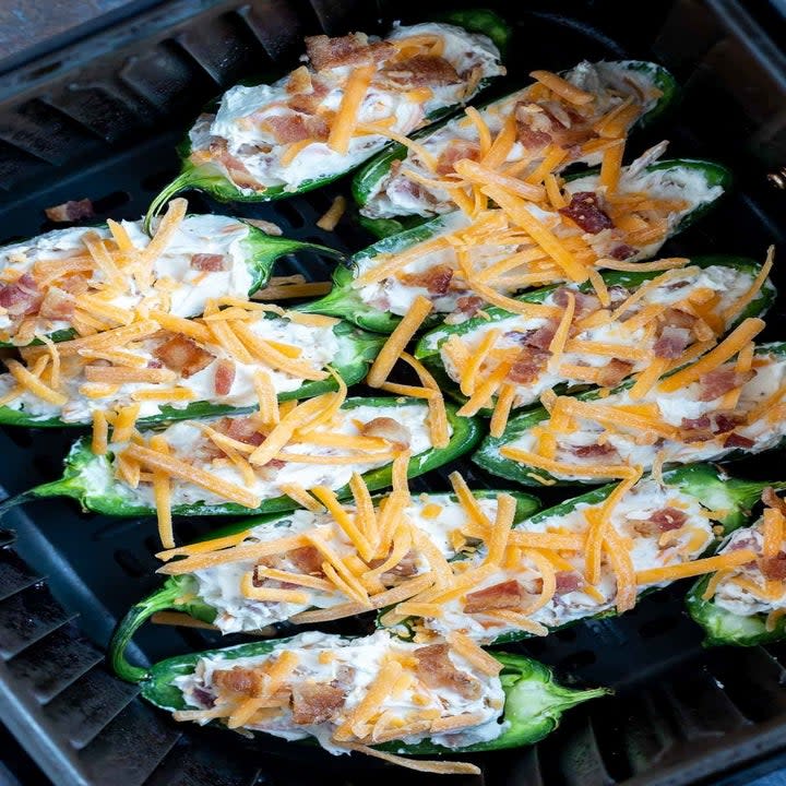 Stuffed jalapeños in an air fryer basket.