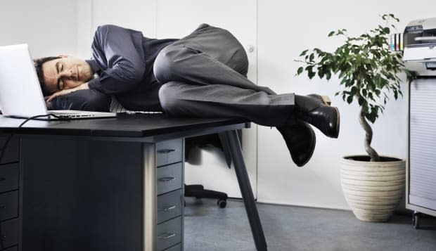 Businessman asleep on his office desk