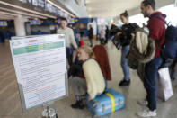 A notice explaining precautions to be taken by people traveling to Wuhan, China, is seen at a terminal of Rome's International Fiumicino airport, Tuesday, Jan. 21, 2020. Heightened precautions are being taken worldwide as a new strain of coronavirus has been infecting hundreds of people across the central Chinese metropolis. (AP Photo/Gregorio Borgia)