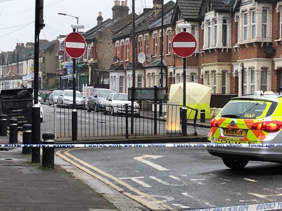 Police at the scene where a man in his 20s died of gunshot and stab wounds in east London on Monday night (Picture: PA)