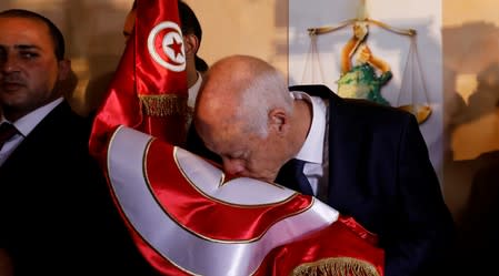 Tunisian presidential candidate Kais Saied reacts after exit poll results were announced in a second round runoff of the presidential election in Tunis