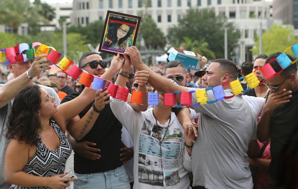 061316 ORLANDO: Friends of Amanda Alvear, who died in the shootings, hold up her photograph and a prayer chain during a vigil for family and friends that have lost loved ones drawing thousands in Orlando, Fla., Monday, June 13, 2016. Curtis Compton / ccompton@ajc.com