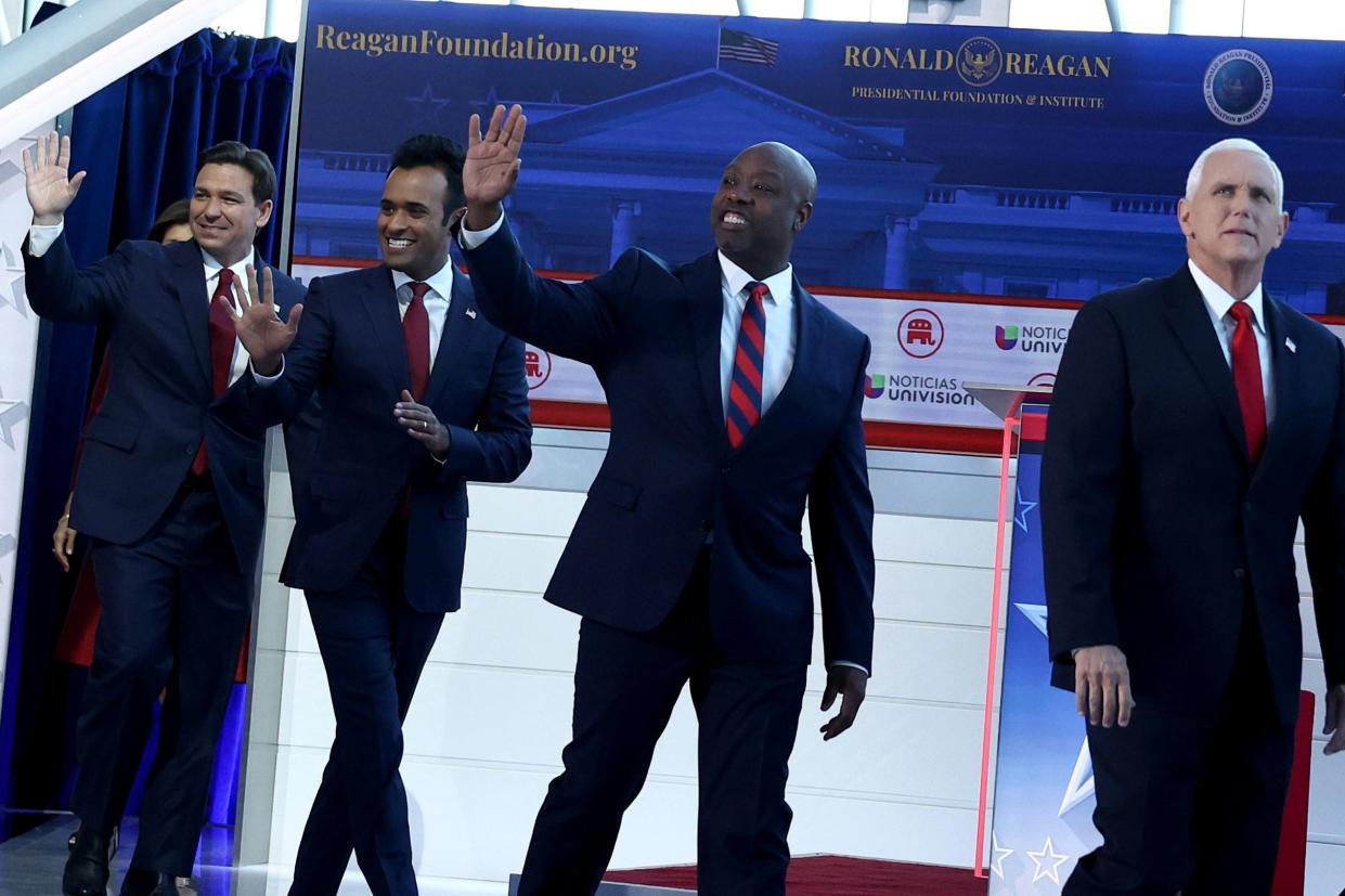 The Republican presidential candidates walk on stage, smile, and wave to the crowd.