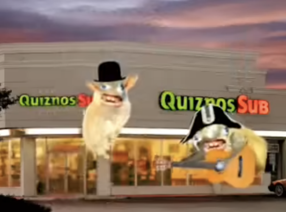 Two characters, one wearing a top hat and another in a tricorn hat with a guitar, appear in front of a Quiznos Sub restaurant