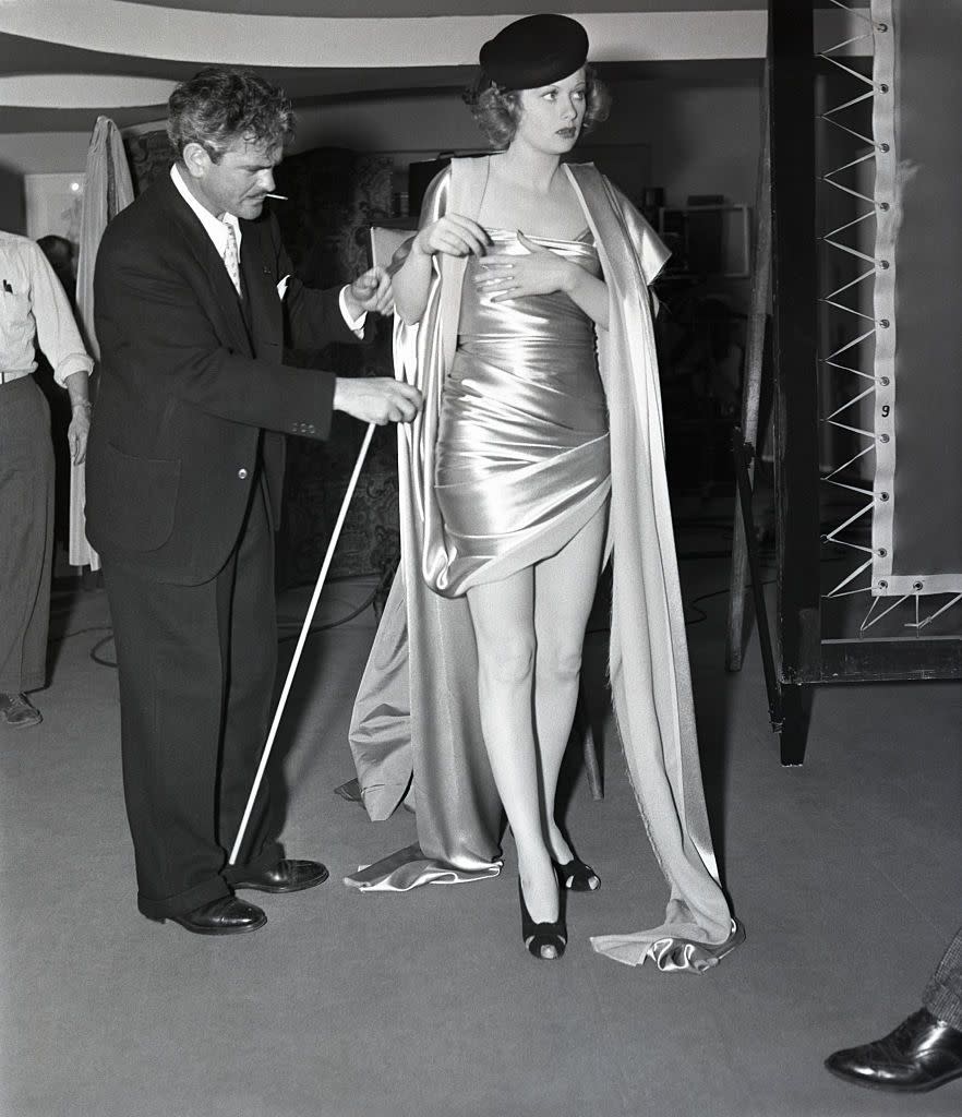 <p>The director of <em>Beauty For the Asking</em> makes sure Lucille's outfit is perfect before shooting a scene for the movie in which the actress portrayed a model.</p>