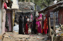 Rohingya refugees stand outside their makeshift camp on the outskirts of Jammu, India, Sunday, March 7, 2021. Authorities in Indian-controlled Kashmir have sent at least 168 Rohingya refugees to a holding center in a process which they say is to deport thousands of the refugees living in the region.(AP Photo/Channi Anand)