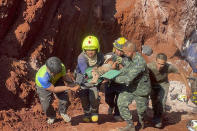 Following an overnight emergency operation, rescue workers and military carry a 1 year-old from a deep hole in the northern Thailand province of Tak, 420 kms. (260 miles) north of Bangkok, Tuesday, Feb. 7, 2023. The toddler, who is from Myanmar, fell into the 15 meter deep hole used for groundwater pipes yesterday evening. (AP Photo/Chiravuth Rungjamratratsami)