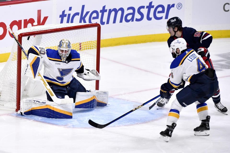 St. Louis Blues goaltender Jordan Binnington (50) gives up a goal to Winnipeg Jets' Kyle Connor, not seen, as Nick Leddy (4) defends against Mark Scheifele (55) during the third period of an NHL hockey game Tuesday, Oct. 24. 2023, in Winnipeg, Manitoba. (Fred Greenslade/The Canadian Press via AP)