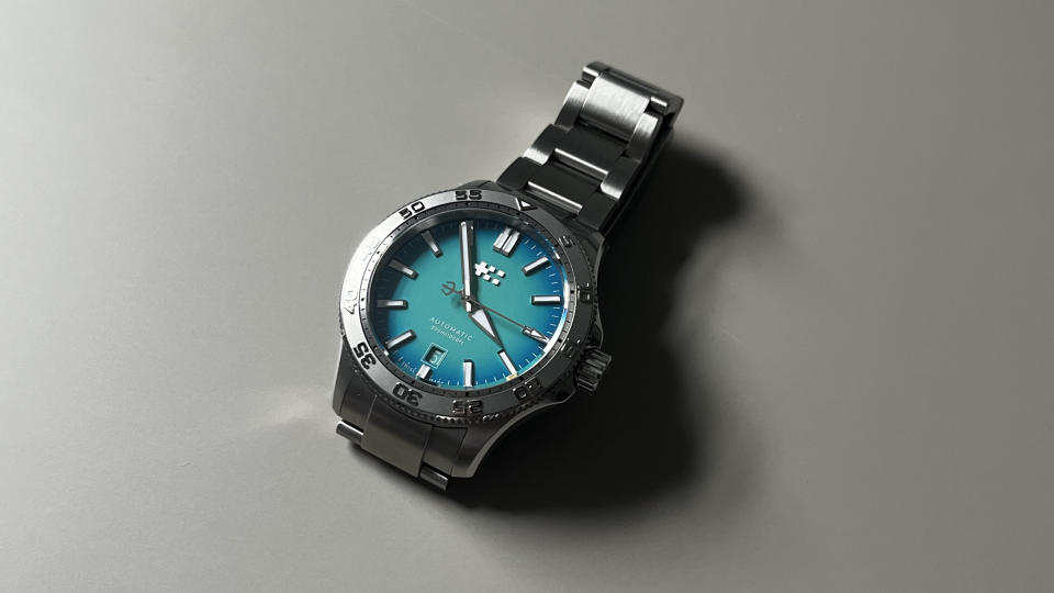 The Christopher Ward C60 Atoll 300 with a blue dial on a grey background