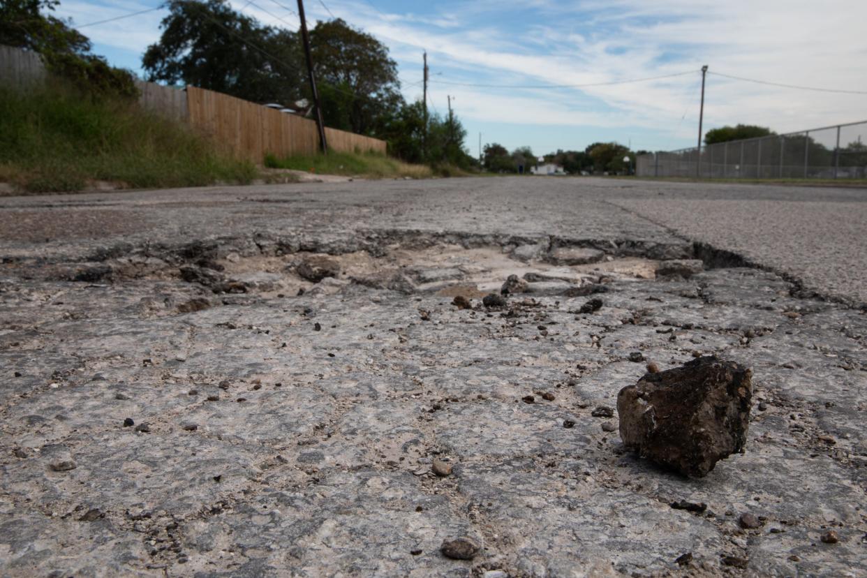 Hunks of pavement are pulled from a pothole by traffic on Castenon Street, Wednesday, Nov. 22, 2023, in Corpus Christi, Texas.