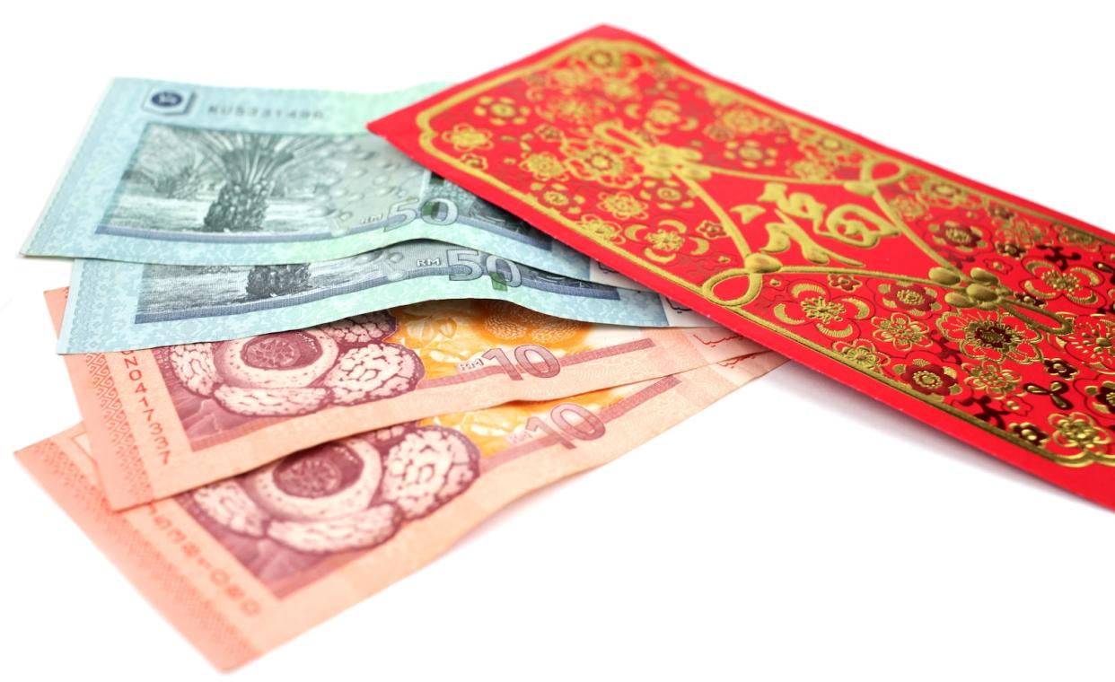 A red packet/ ang pow usually given during Chinese New Year and a few Malaysian ringgit notes.