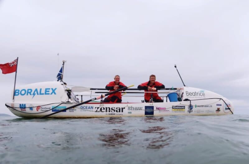 The crew of the Long Way Home in their boat.