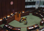 Firefighters wearing gas masks check the main chamber of the Legislative Council after a pro-democracy lawmaker hurled an object during the second day of debate on a bill that would criminalize insulting or abusing the Chinese anthem in Hong Kong, Thursday, May 28, 2020. Three pro-democracy lawmakers were ejected from Hong Kong's legislative chamber Thursday morning, disrupting the start of the debate on the contentious bill. (AP Photo/Vincent Yu)