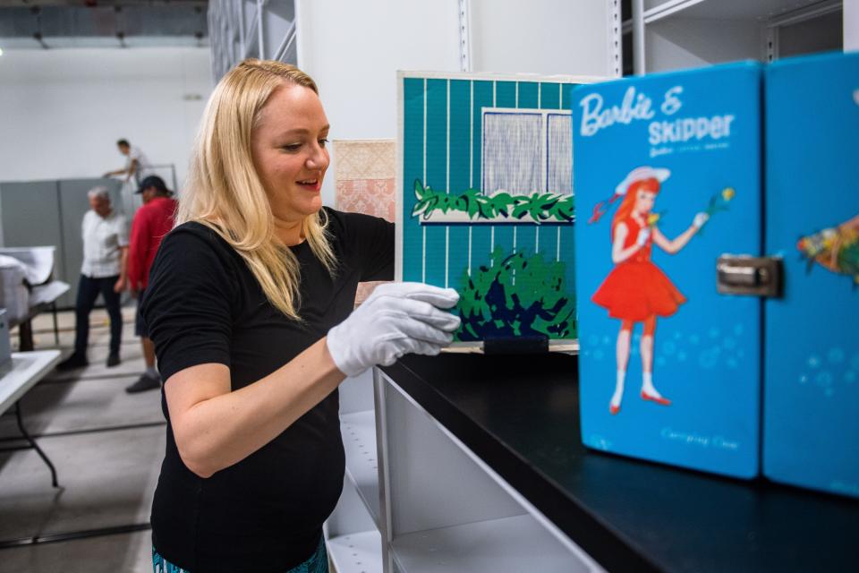 Lesley Struc, curator of the Local History Archive at the Fort Collins Museum of Discovery, displays a Barbie house in the museum's collection on July 21. The donor of the item also gave handmade, Barbie-sized knitted clothing.