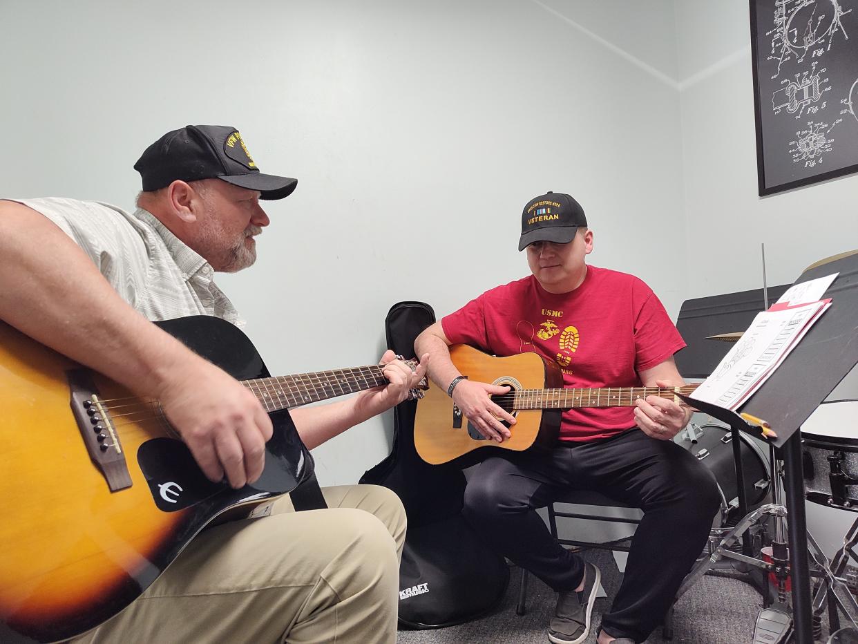 Rodney Temple, left, is shown giving a guitar lesson to Kevin Watter at the West Bend Music Academy through the Guitars 4 Vets program. Guitars 4 Vets is a nonprofit organization that teaches veterans to play the guitar and cope with PTSD through music. Washington County started a Guitars 4 Vets chapter on April 1.