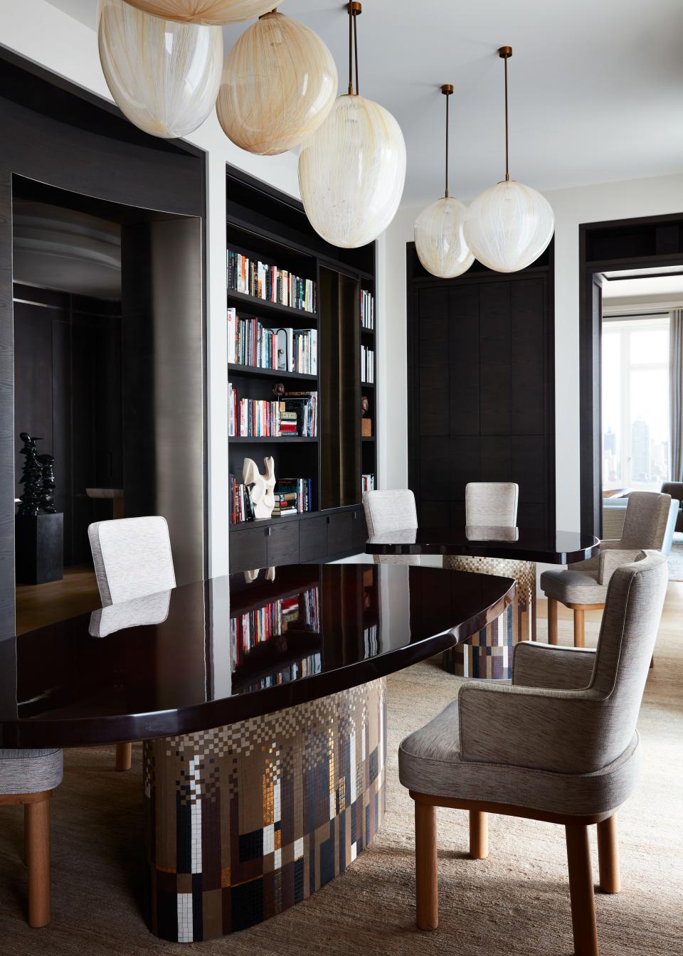 Yovanovitch joined the former study and the dining room to create a large hybrid space, and designed this undulating two-piece table, with a mosaic base by Mathilde Jonquière and a lacquered top by Atelier Midavaine, to be used in multiple ways. “It's almost like a family room; we have casual dinners here and watch TV, which is hidden,” says Zaoui. “And if we have guests, we bring the tables together.”