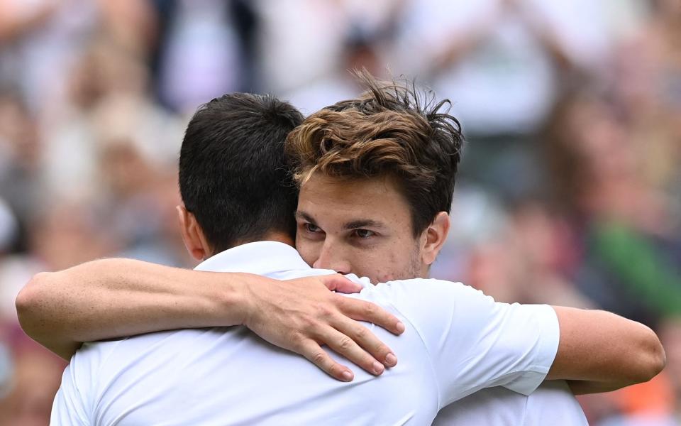 Djokovic and Miomir Kecmanovic embrace at the net - AFP