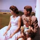 <p>Senator John F Kennedy relaxes with his wife Jackie and their daughter Caroline. </p>