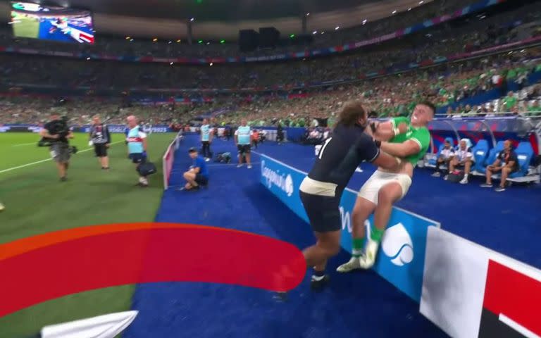 El escocés Pierre Schoeman tira contra una valla publicitaria al irlandés Dan Sheehan durante Escocia vs. Irlanda, en el Stade de France; un hecho inusual en el Mundial de rugby.