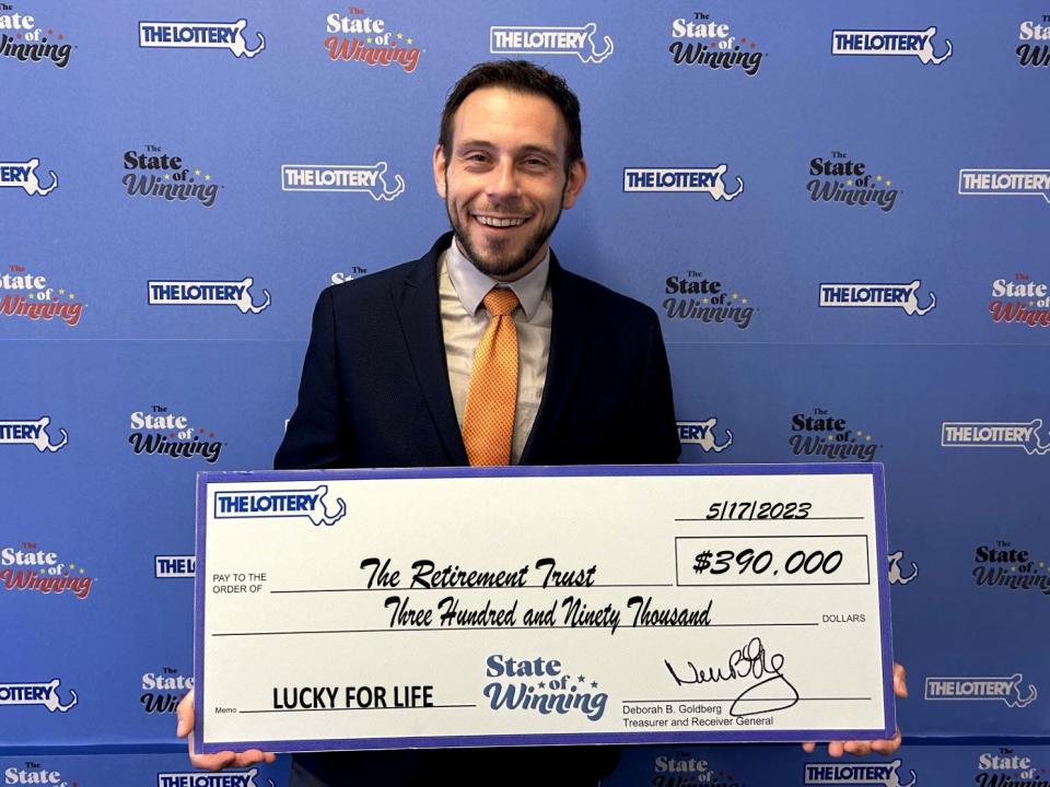 Luke Bean, trustee for The Retirement Trust of Natick, poses with an outsized check after claiming a winning Lucky for Life ticket that was due to expire May 17.