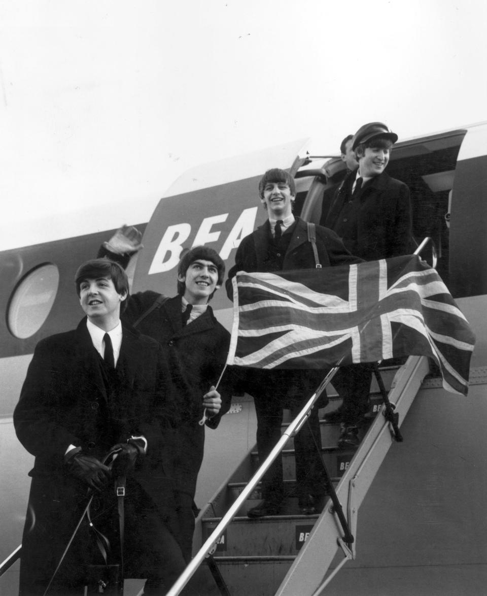 En 1964, The Beatles ya eran estrellas en Estados Unidos, pero nunca habían viajado hasta allí. Esta imagen fue tomada el 8 de febrero de aquel año, cuando la banda subía a un avión en Londres para cruzar el charco por primera vez. (Foto: Evening Standard / Getty Images).