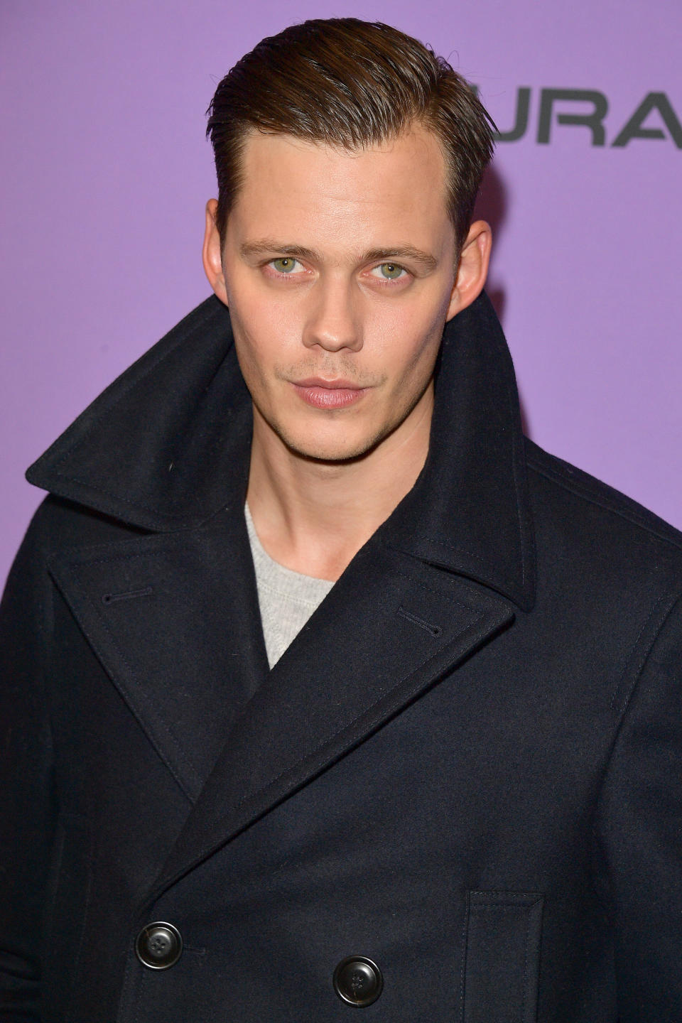 Bill Skarsgård in a black peacoat on the red carpet