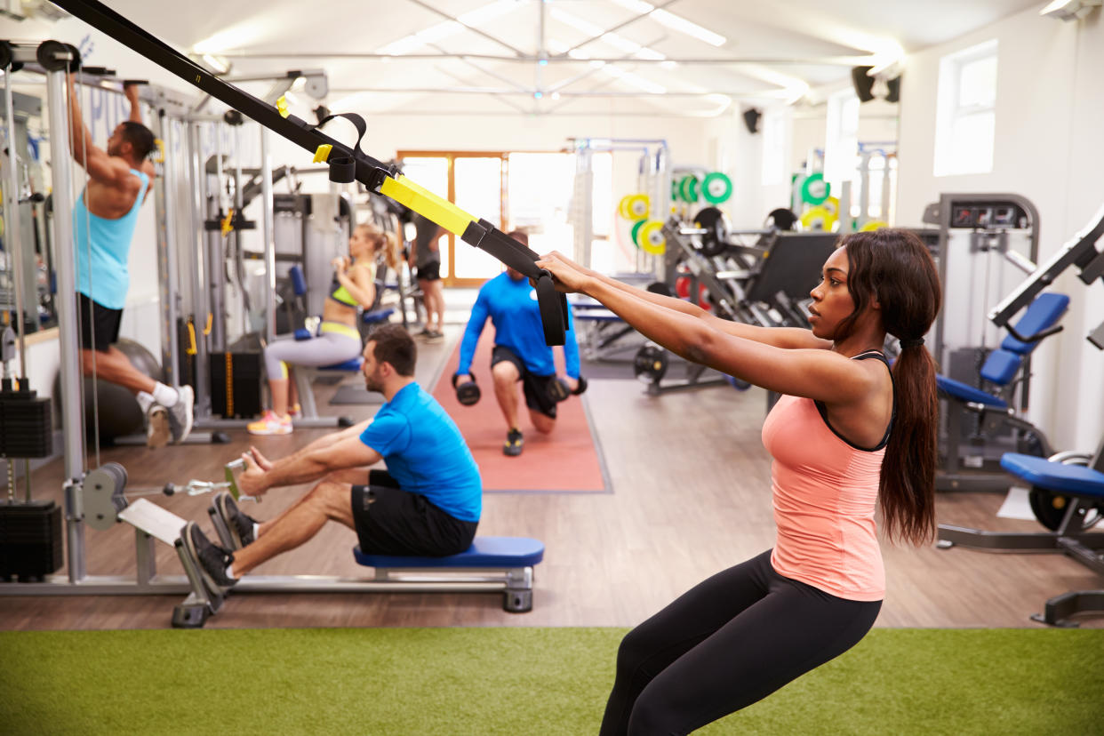 People working out on fitness equipment at a busy gym. (Getty Images)