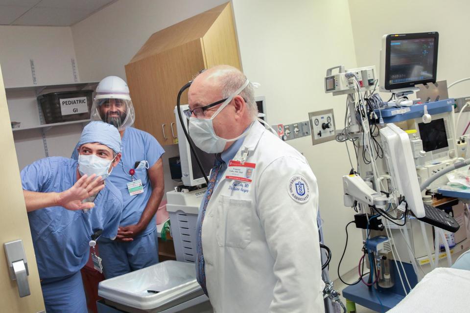 Dr. Michael Herzlinger, left, greets visitors to one of the new pediatric endoscopy rooms during a tour of the ongoing renovations at Hasbro Children's Hospital. Looking on are Dr. Muhammad Riaz, rear, and Dr. François Luks, pediatric surgeon in chief.