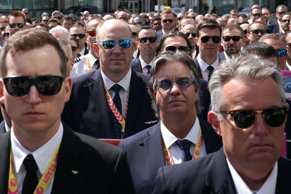 WestJet Airlines pilots assemble for a group photo after standing on a picket line at Toronto’s Pearson Airport on May 8, 2023. THE CANADIAN PRESS/Chris Young