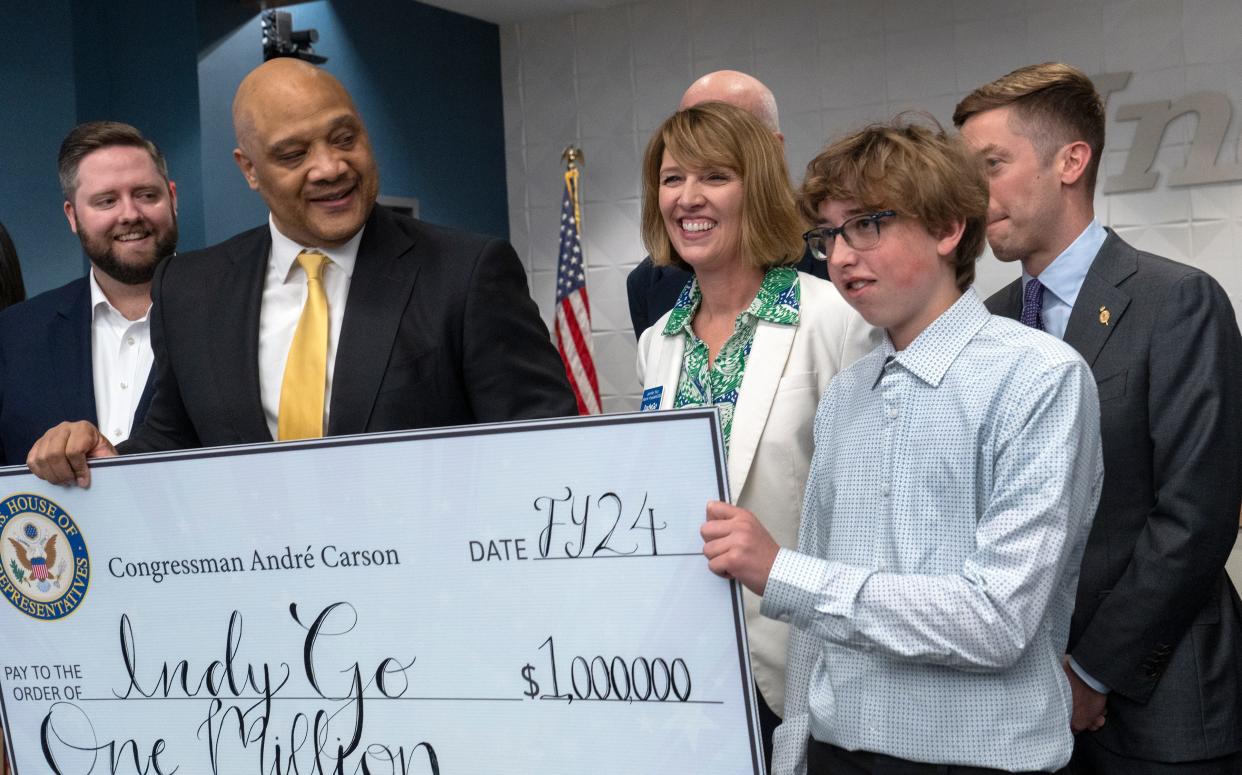 Rep. Andre Carson poses for photos with IndyGo Interim President/CEO Jennifer Pyrz , center, and other IndyGo representatives as well as IPS George W. Julian School 57 student Reese McClure, right, after the congressman spoke at IndyGo east campus Thursday, April 25, 2024 about getting money in the federal budget for the Blue Line project. Reese will be riding the Blue Line to school.