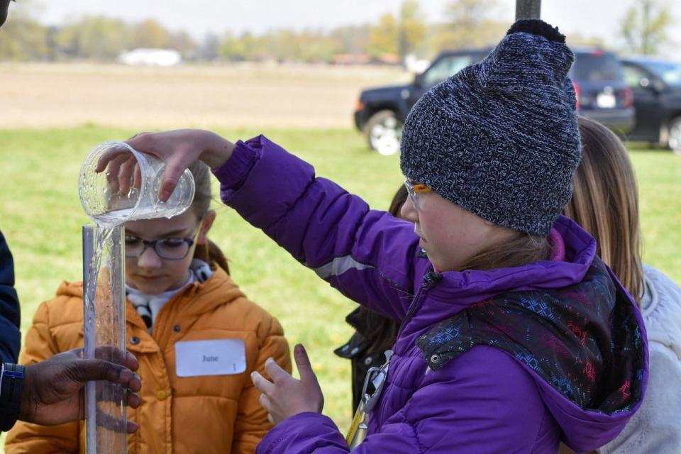 A student from Immaculate Conception School of Port Clinton pours a water sample into a tube.