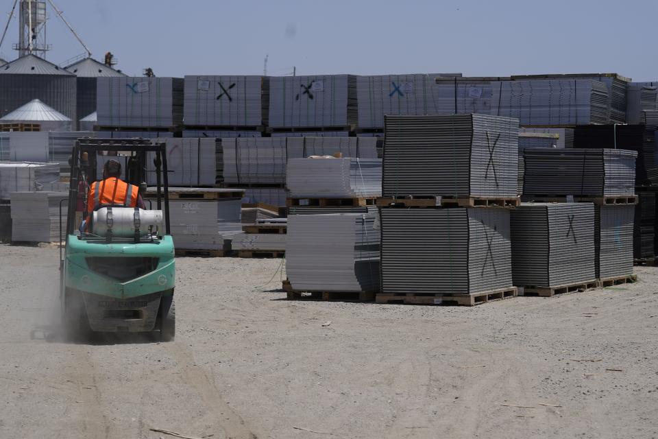A worker drives a fork lift near rows of used solar panels as they begin the recycling process at We Recycle Solar on Tuesday, June 6, 2023, in Yuma, Ariz. North America’s first utility-scale solar panel recycling plant opened to address what founders of the company call a “tsunami” of solar waste, as technology that became popular in the early 2000s rapidly scales up. (AP Photo/Gregory Bull)