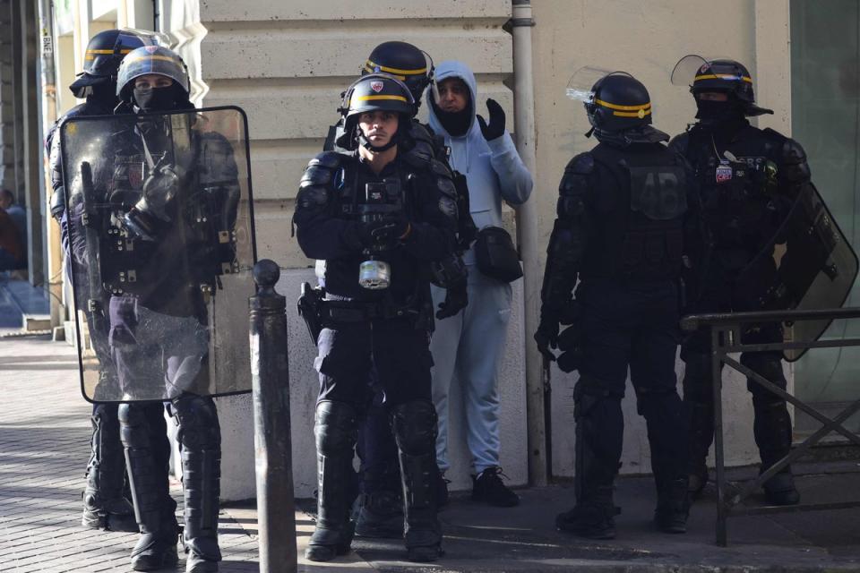 A man reacts as he is detained and questioned by police officers during a demonstration against police in Marseille (AFP via Getty Images)