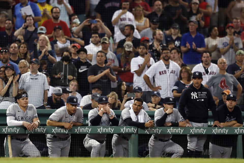 New York Yankees players watch from the dug out during the ninth inning of a baseball game against the Boston Red Sox, Saturday, June 26, 2021, in Boston. (AP Photo/Michael Dwyer)
