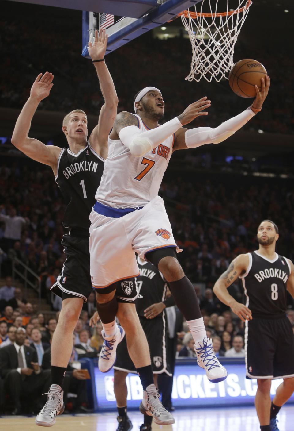 New York Knicks' Carmelo Anthony (7) drives past Brooklyn Nets' Mason Plumlee (1) during the first half of an NBA basketball game Wednesday, April 2, 2014, in New York. (AP Photo/Frank Franklin II)