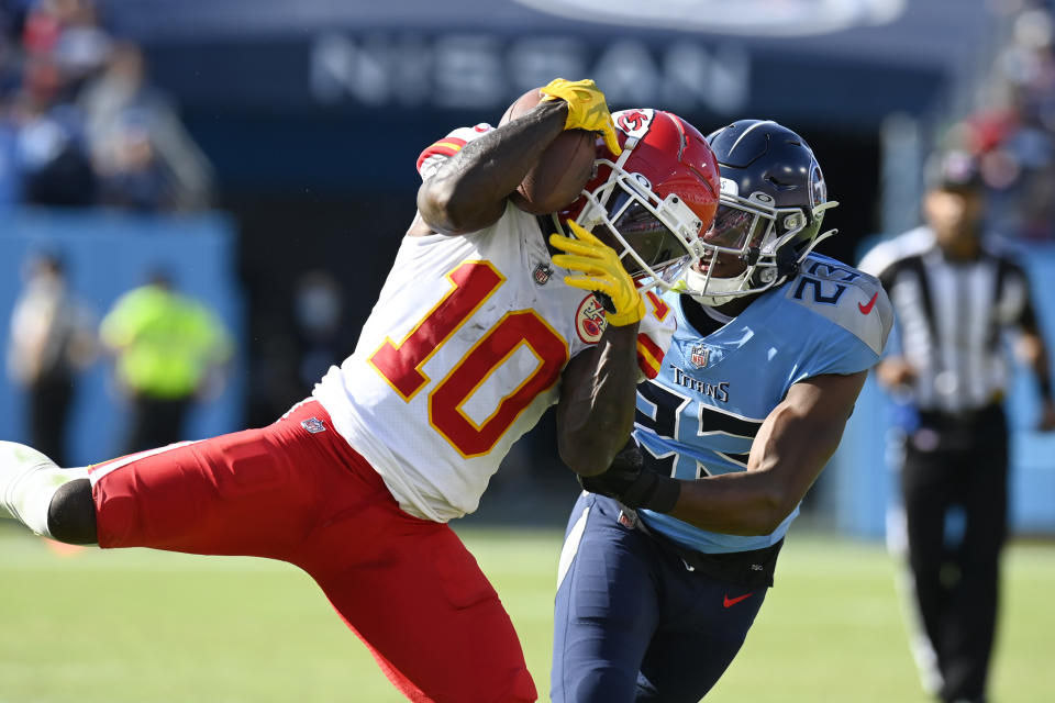 Kansas City Chiefs wide receiver Tyreek Hill (10) catches a pass as he is defended by Tennessee Titans cornerback Chris Jones (23) in the second half of an NFL football game Sunday, Oct. 24, 2021, in Nashville, Tenn. (AP Photo/Mark Zaleski)