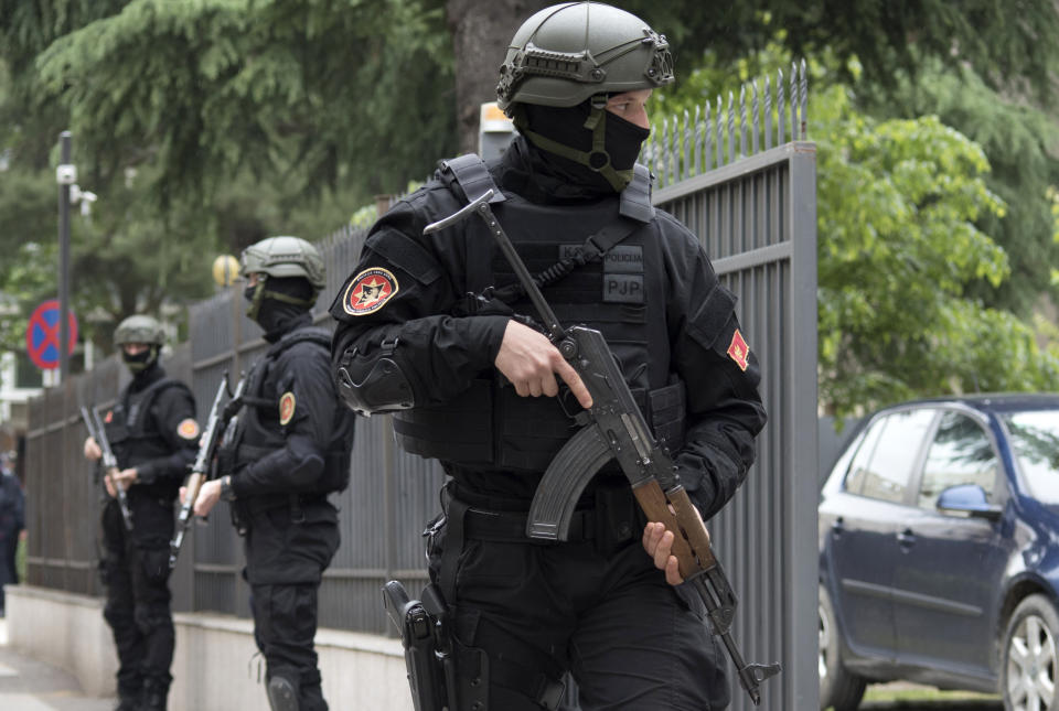 Montenegro police officers guard the entrance to the court during the verdict in the case of ''attempted terrorism'' and ''creating a criminal organization'', in Podgorica, Montenegro, Thursday, May 9, 2019. A court in Montenegro has sentenced 13 people, including two Russian secret service operatives, to up to 15 years in prison after they were found guilty of plotting to overthrow the Balkan country's government and prevent it from joining NATO. (AP Photo/Risto Bozovic)