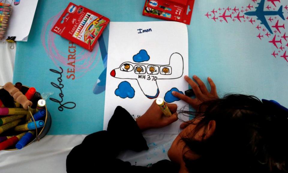 The daughter of MH370 flight attendant Mohamad Hazrin Hasnan draws the plane during its fourth annual remembrance event in Kuala Lumpur.