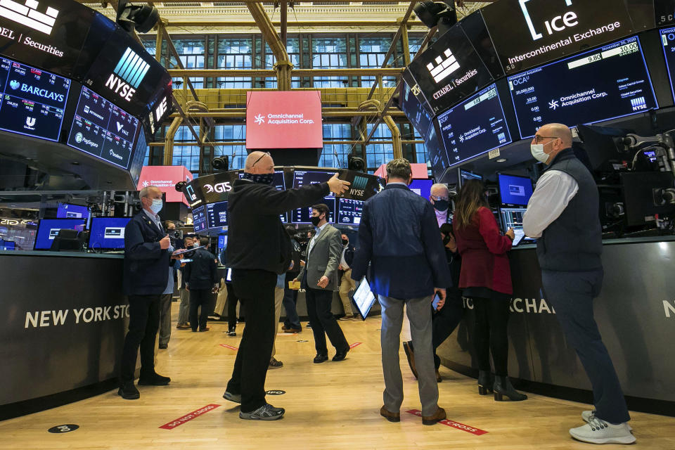 In this photo provided by the New York Stock Exchange, traders work on the floor Friday, Nov. 20, 2020. U.S. stocks are pulling a bit lower in midday trading Friday as worries about the worsening pandemic weigh on rising optimism about a coming coronavirus vaccine. (Courtney Crow/New York Stock Exchange via AP)