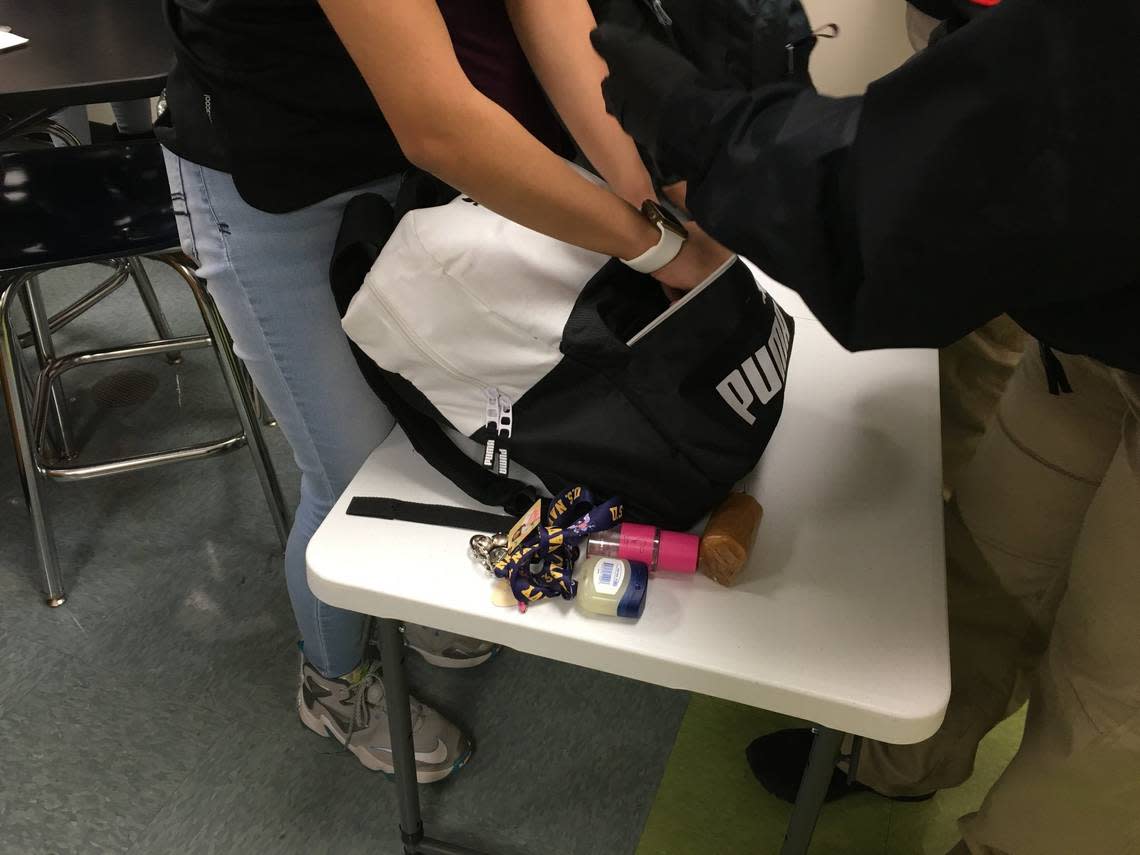 A Rocky River High School student in Mint Hill, N.C., removes items from a book bag during a gun search on Jan. 29, 2019.