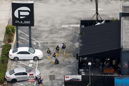 Federal Bureau of Investigation (FBI) officials walk through the parking lot of the Pulse gay night club, the site of a mass shooting days earlier, in Orlando, Florida, U.S., June 15, 2016. REUTERS/Adrees Latif