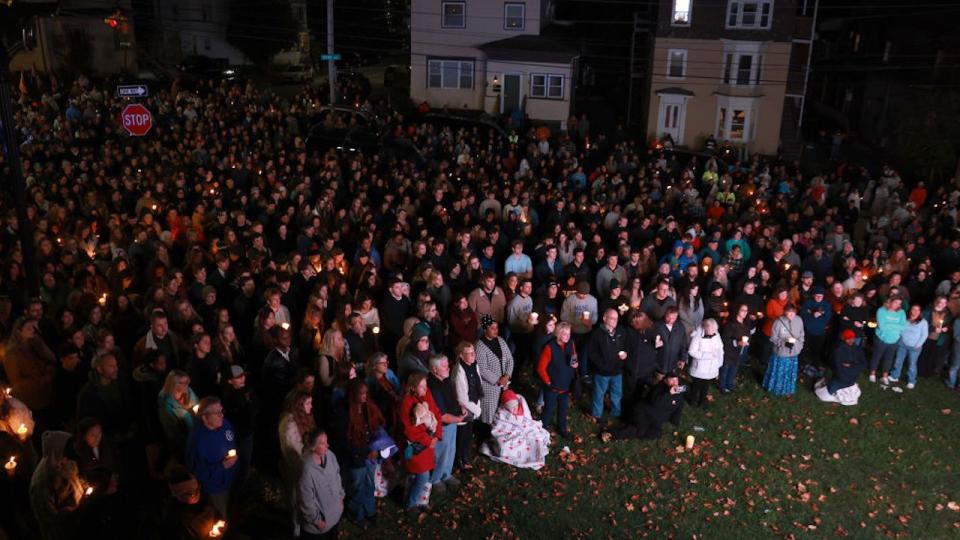 An overflow crowd watches a television screen as it broadcasts from inside the Basilica of Saints Peter and Paul in Lewiston.