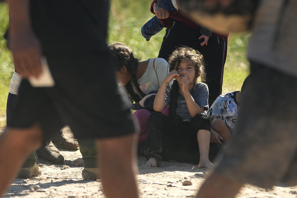 Migrants wait to be processed by the U.S. Customs and Border Patrol after they crossed the Rio Grande and entered the U.S. from Mexico, Thursday, Oct. 19, 2023, in Eagle Pass, Texas. Starting in March, Texas will give police even broader power to arrest migrants while also allowing local judges to order them out of the U.S. under a new law signed by Republican Gov. Greg Abbott. (AP Photo/Eric Gay)