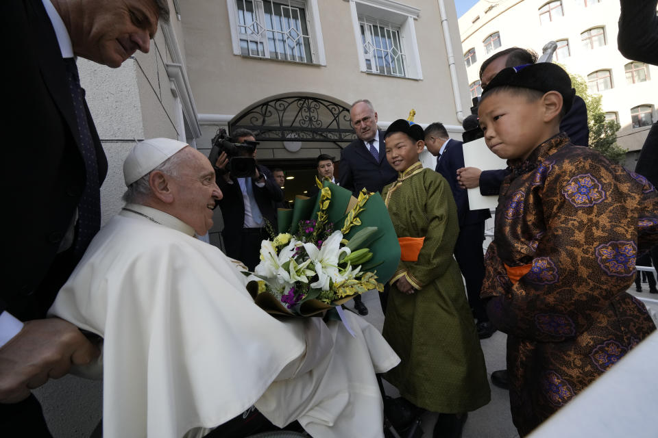 Children in traditional dress welcome Pope Francis arriving for a meeting with charity workers and for the inauguration of the House of Mercy in Ulaanbaatar, Monday, Sept. 4, 2023. Francis toured the House of Mercy in the final event of an historic four-day visit to a region where the Holy See has long sought to make inroads. (AP Photo/Andrew Medichini)