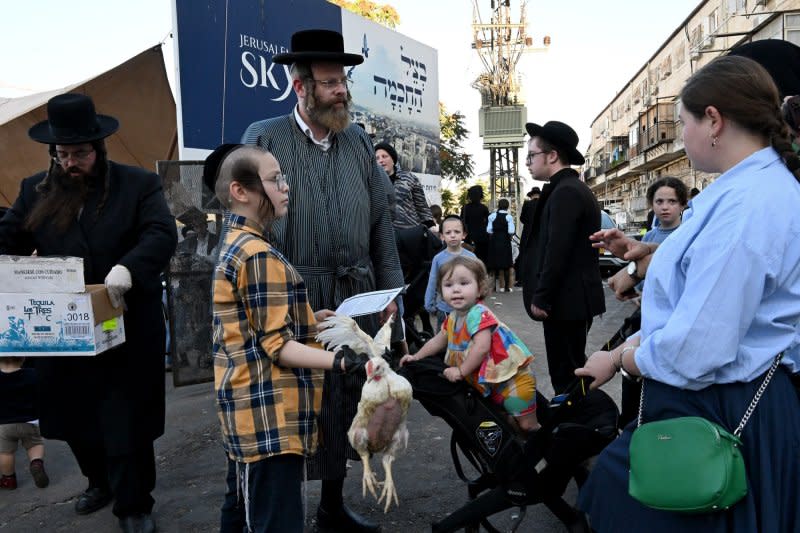 An Ultra-Orthodox Jewish boy holds a chicken to use in the ancient ritual Kapparot in Mea Shearim in Jerusalem on Thursday. Kapparot is performed before Yom Kippur, the Day of Atonement, the holiest day of the Jewish calendar, and symbolically transfers the sins of the past year to the chicken. Photo by Debbie Hill/UPI