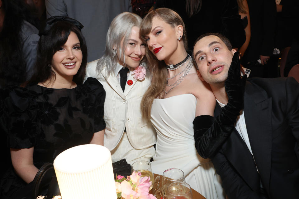 Lana and Taylor smiling and sitting with others at the Grammys