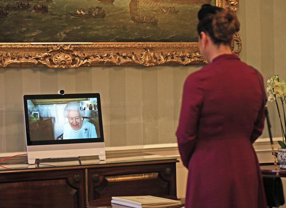 Queen Elizabeth II (L) appears on a screen by videolink from Windsor Castle, during a virtual audience to receive Her Excellency Sophie Katsarava (R), the Ambassador of Georgia, who was at London's Buckingham Palace on December 4, 2020. - Today, Britain's Queen Elizabeth II conducted the first virtual Audiences from Buckingham Palace, via video link from Windsor Castle. (Photo by Yui Mok / POOL / AFP) (Photo by YUI MOK/POOL/AFP via Getty Images)