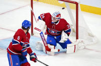 The puck flies into the net past Montreal Canadiens goaltender Jake Allen (34) on a goal by Vancouver Canucks' Elias Pettersson, not seen, as defenseman Ben Chiarot (8) looks on during the first period of an NHL hockey game, Monday, Nov. 29, 2021 in Montreal. (Paul Chiasson/The Canadian Press via AP)